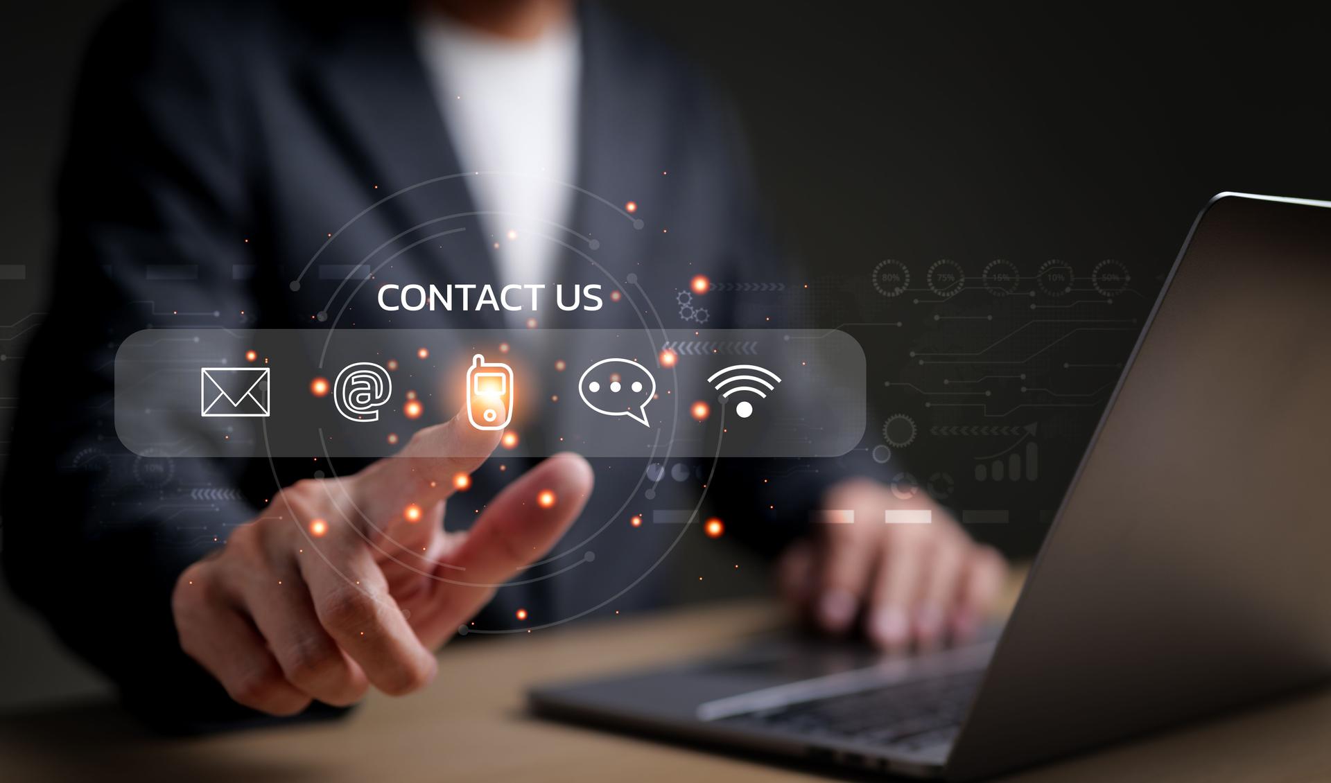 Businessman using a laptop and touching on virtual screen contact icons consists of telephone, email, address, live chat, internet wifi, Contact us or Customer care support hotline people connect.